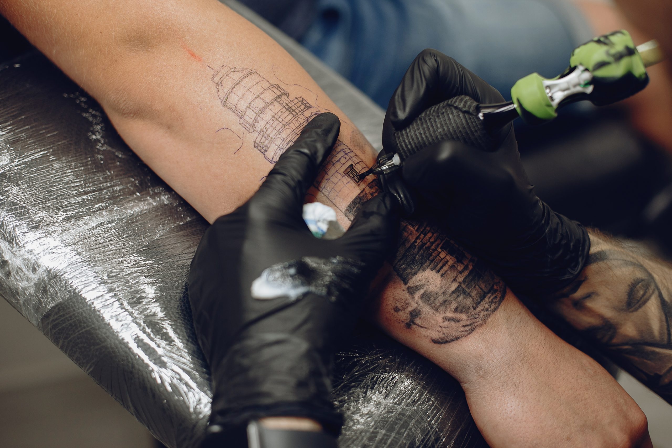 man-doing-a-tattoo-in-a-tattoo-salon-2021-08-26-18-31-13-utc-scaled.jpg